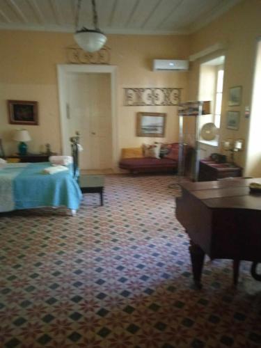 Habitación de hotel con cama y sofá en ALIKIS OLD 1875 HOUSE VARRES BOHALI ZAKYNTHOS en Zakynthos