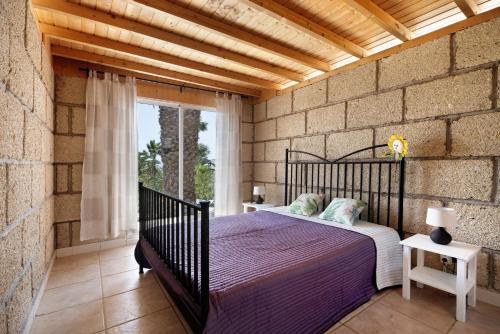 a bedroom with a bed and a brick wall at Finca Firmamento, Casa Sol in San Isidro