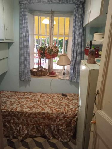 1 dormitorio con 1 cama y ventana con lámpara en ALIKIS OLD 1875 HOUSE VARRES BOHALI ZAKYNTHOS en Zakynthos