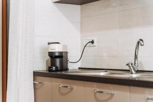 a coffee maker on a counter next to a sink at La foresteria di Mony e Ale in Carbonia