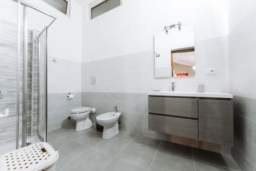a bathroom with a toilet and a sink and a mirror at La foresteria di Mony e Ale in Carbonia
