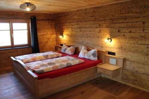 1 dormitorio con 2 camas en una cabaña de madera en Panoramahof Monika Kennerknecht, en Akams