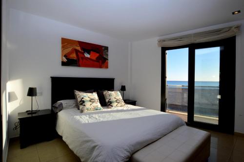 een slaapkamer met een bed en uitzicht op de oceaan bij Apartamento delante del mar in Can Pastilla