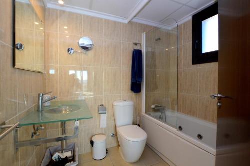 a bathroom with a toilet and a sink and a tub at Apartamento delante del mar in Can Pastilla