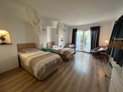 una habitación de hotel con 2 camas y una silla en Beyaz Ev, en Seferihisar