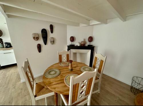 una sala da pranzo con tavolo e sedie in legno di C La reserve - St ROSE Ethnique a Clermont-Ferrand