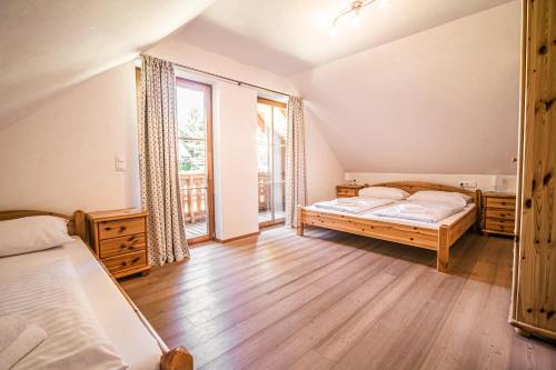 a bedroom with two beds and a large window at Cozy Alpin-Hütte Haus Murmeltier by S4Y in Turracher Hohe