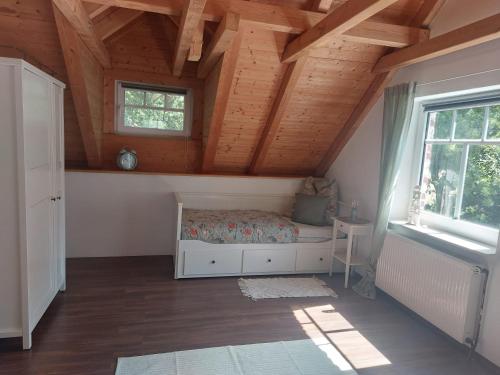 - une chambre avec un lit dans une pièce dotée de plafonds en bois dans l'établissement Elli, à Berumbur