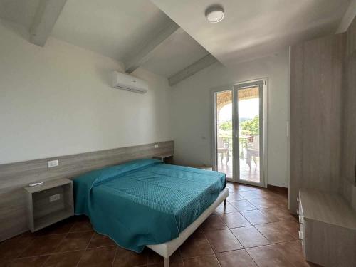 ein Schlafzimmer mit einem blauen Bett und einem Fenster in der Unterkunft Appartamento Santa Lucia E in Policastro Bussentino