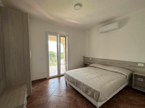 1 dormitorio con cama y ventana grande en Appartamento Santa Lucia F, en Policastro Bussentino