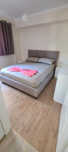 a large bed in a room with a wooden floor at Brand New Apartment Gjirokaster in Gjirokastër