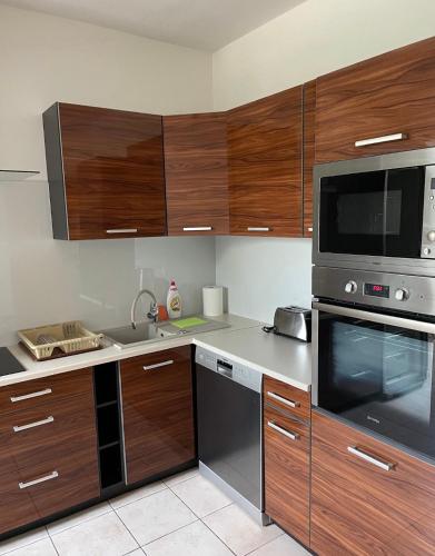 a kitchen with wooden cabinets and stainless steel appliances at Jahodná in Košice