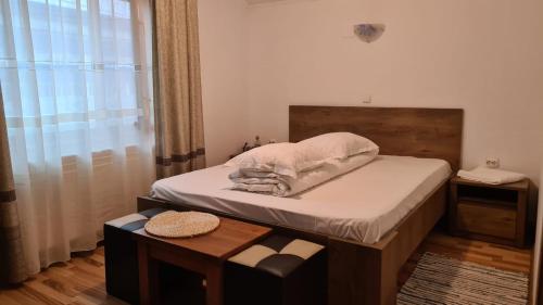 a small bedroom with a bed and a table at Hanul Ancutei in Curtea de Argeş