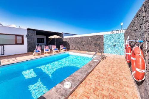 a villa with a swimming pool and a house at Villa Aurelia - Pool, Jacuzzi, BBQ and Ping-Pong By Lanzarote Vacation Homes in Playa Blanca