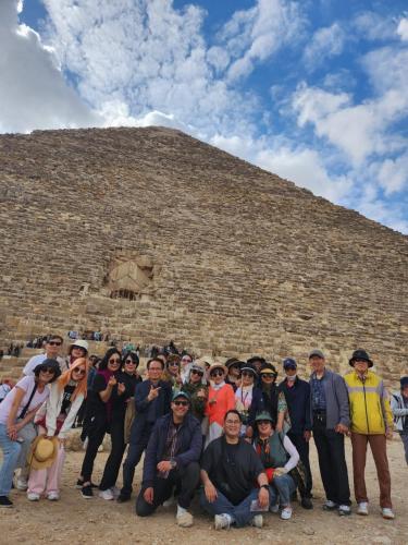 a group of people posing in front of a pyramid at Sooly pyramids Inn in Cairo