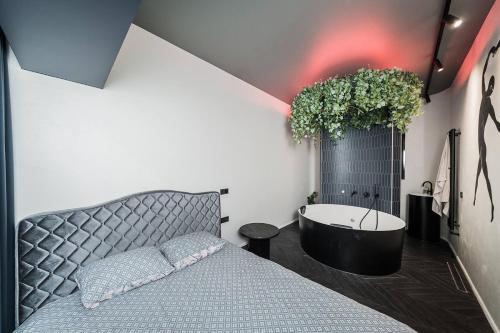 Schlafzimmer mit einem Bett und einer Badewanne in der Unterkunft Butas su Jacuzzi Kauno miesto centre in Kaunas