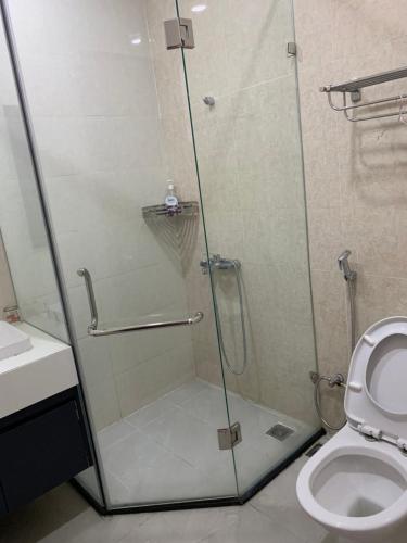 a shower with a glass door next to a toilet at Golden Lotus Homestay Phú Quốc in Phu Quoc