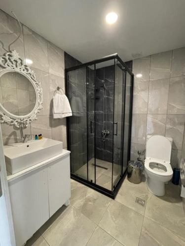uma casa de banho com um chuveiro, um WC e um lavatório. em Yalı Beach Houses em Istambul