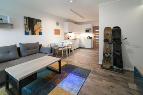 a living room with a couch and a table at Apartamenty Nad Żylicą przy deptaku - Dream Apart in Szczyrk