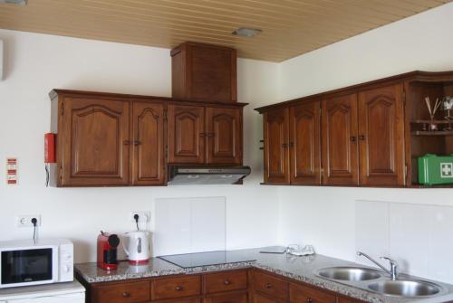una cocina con armarios de madera y fregadero en LG STAY, en Castro Daire