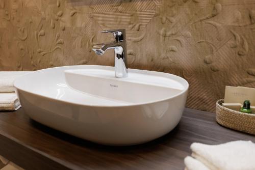a bathroom with a white sink on a wooden counter at Darovanský Dvůr - Wellness & Golf Hotel in Břasy