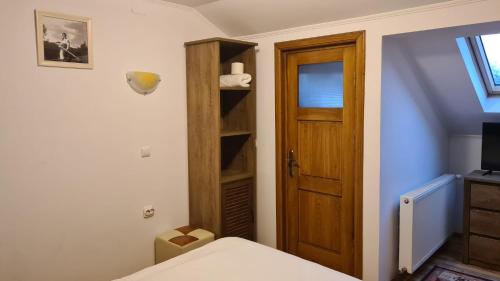 a bedroom with a bed and a wooden door at Hanul Ancutei in Curtea de Argeş
