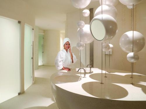 a woman standing in a bathroom with balloons at Novotel Bangkok Platinum Pratunam in Bangkok