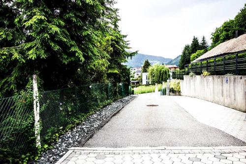an empty road with a fence and trees and a building at Ferienwohnung in Feldkirchen Dagmar und Christian! in Feldkirchen in Kärnten