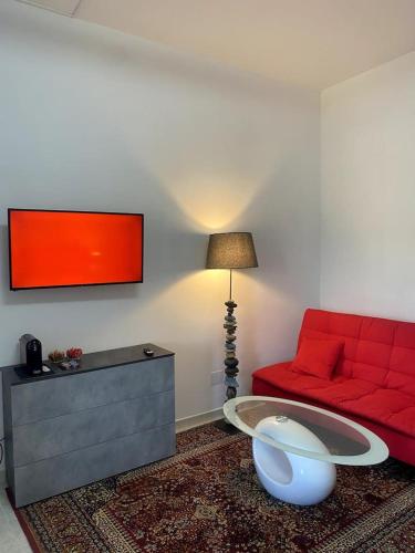 a living room with a red couch and a table at Mini Red Hub - Design Apartment in SantʼAgapito