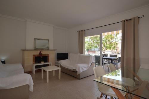 Elle comprend un salon doté d'un mobilier blanc et d'une cheminée. dans l'établissement Apartamento en Alcudia a 100 metros de la playa, à Alcúdia