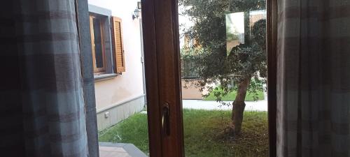 Casa Lilla 1 e 2 في أوريستانو: باب مفتوح على ساحة فيها شجرة
