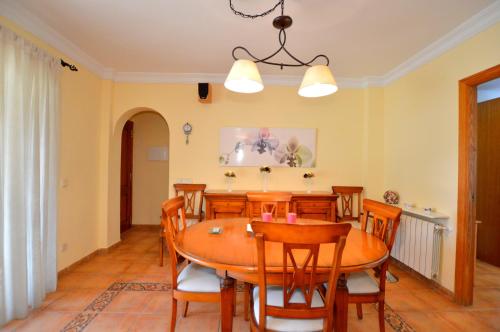 a dining room with a wooden table and chairs at Bonito chalet con piscina cerca del mar in Can Pastilla