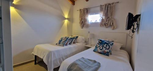 ein kleines Zimmer mit 2 Betten und einem Fenster in der Unterkunft Agradable finca en un entorno natural in Lloseta