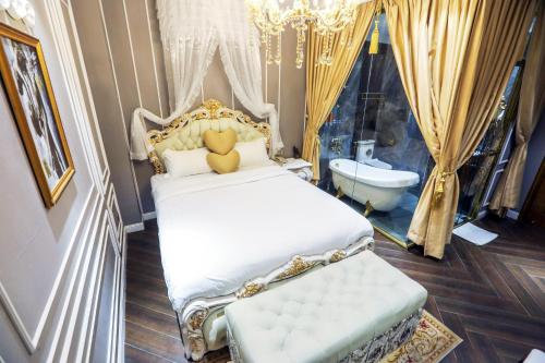 a bedroom with a bed and a bathroom with a tub at ENJOY HOTEL 2 in Ho Chi Minh City