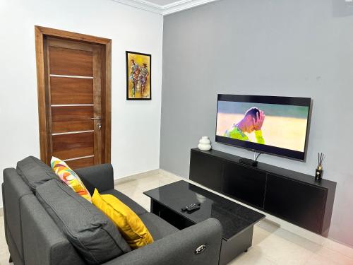 a living room with a couch and a flat screen tv at Westlands Tower - Ghana Villas in Accra