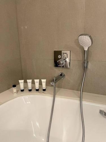 a bathroom with a tub with a shower head at Address Resort Apartments Fujairah - 2 bedroom apartment in Fujairah