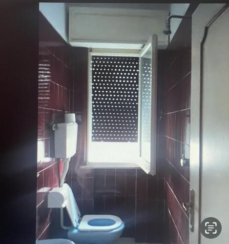 een badkamer met een blauw toilet en een raam bij HOTEL ME.BE NEW in Rimini