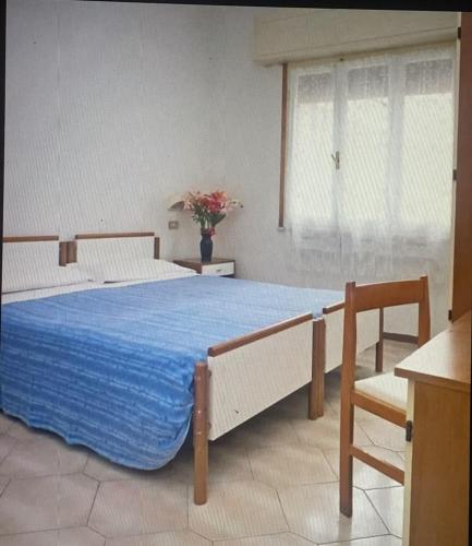 een slaapkamer met een groot bed en een blauwe deken bij HOTEL ME.BE NEW in Rimini