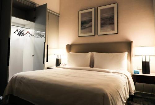 Address Resort Apartments Fujairah - 2 bedroom apartment في الفجيرة: غرفة نوم بسرير كبير فيها مصباحين