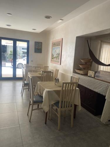 een eetkamer met een tafel en stoelen en een spiegel bij HOTEL ME.BE NEW in Rimini