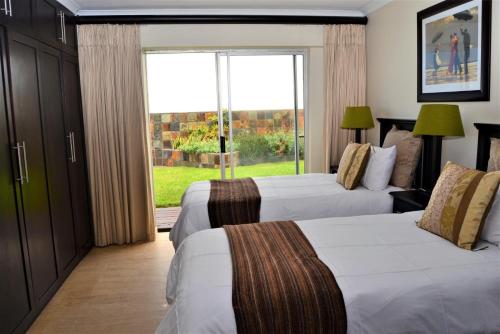 a hotel room with two beds and a window at 26 Bronze Bay Umhlanga Rocks in Durban