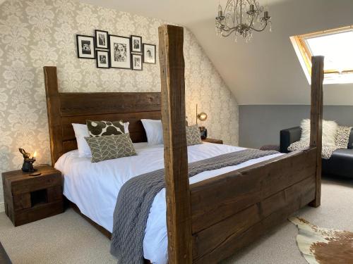 a bedroom with a wooden bed with white sheets at Floyter House North Yorkshire Moors National Park in Danby