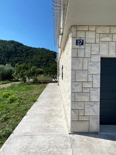 ein Gebäude mit einer blauen Garagentür und einem Gehweg in der Unterkunft Villa Dolina in Opuzen