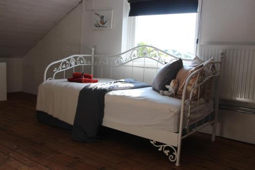 a white bed in a room with a window at CosyPlace; close to beach, nature, train, grocery in Köpingebro