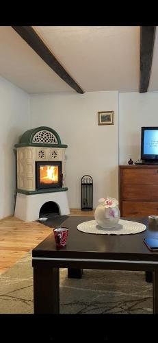 a living room with a fireplace and a table with a cake at Wooden house Mali Vrh in Kamanje