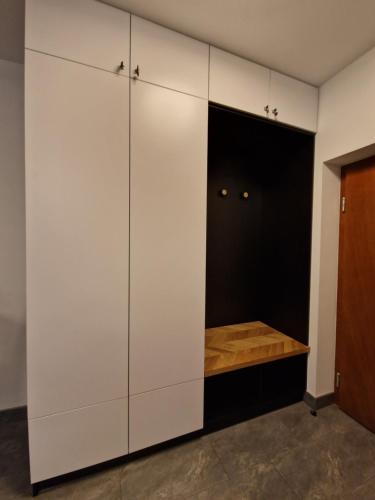 a closet with white cabinets in a room at Apartament Cygański Las in Bielsko-Biała