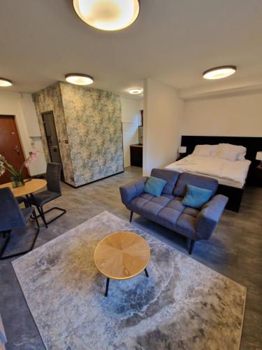 a bedroom with a bed and a couch and a table at Apartament Cygański Las in Bielsko-Biała
