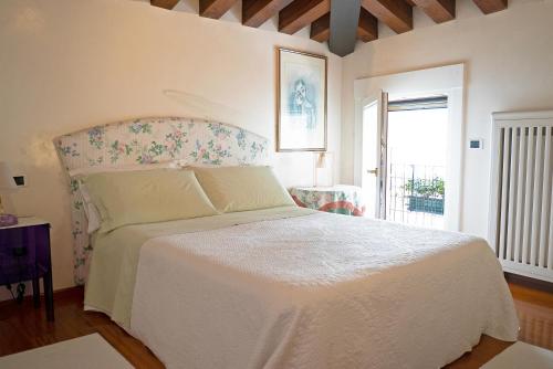 a bedroom with a white bed and a window at Mini Suite Deluxe Isola di Mezzo in Treviso