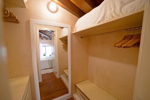 a walk in closet with ajar door and a mirror at Mini Suite Deluxe Isola di Mezzo in Treviso
