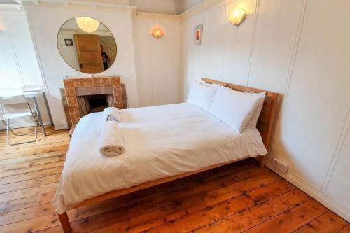 Schlafzimmer mit einem Bett, einem Kamin und einem Spiegel in der Unterkunft Free Parking-Central Location in Cardiff